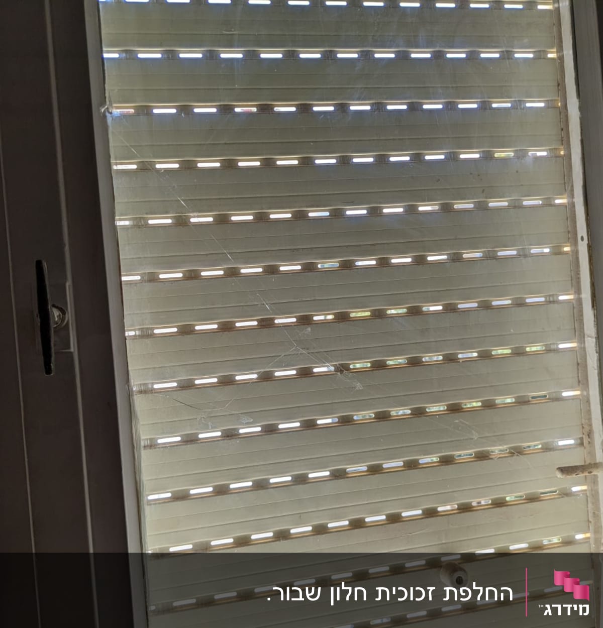 חלון זכוכית עם תריסים סגורים ושריטות קלות